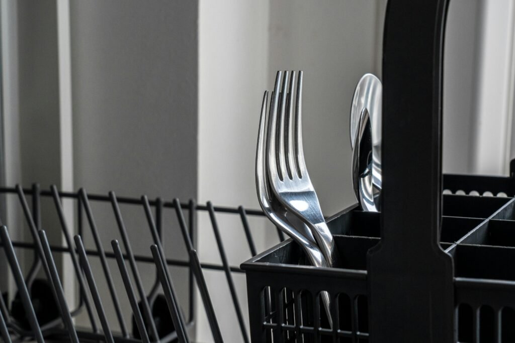 "Dishwasher silverware basket with clean forks and utensils inside a modern dishwasher in Colorado Springs, CO.