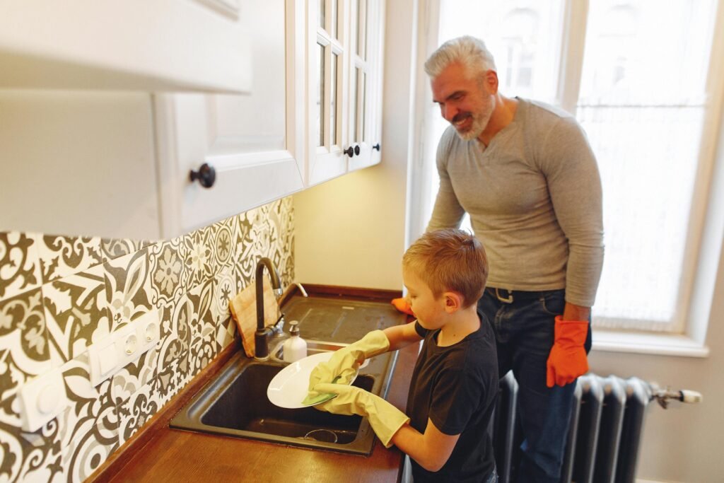 "Father and child cleaning dishes in a modern kitchen before dishwasher repair in Colorado Springs, CO.