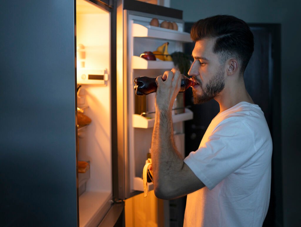 Person checking a refrigerator before repair in Colorado Springs